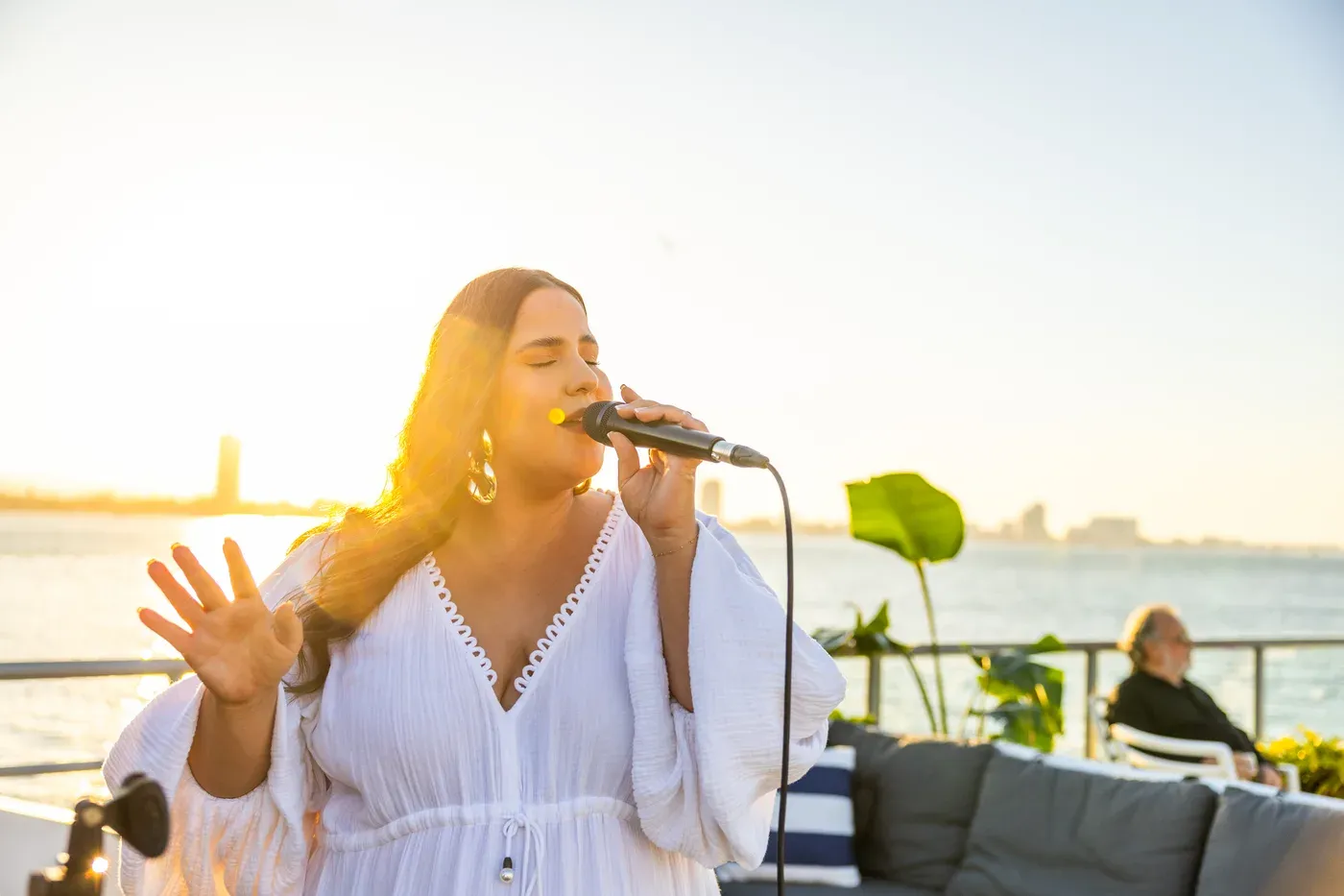 A singer performing on deck with the waterways behind her
