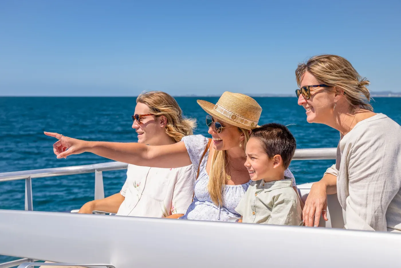 A family looking out across the ocean from the whale watching vessel