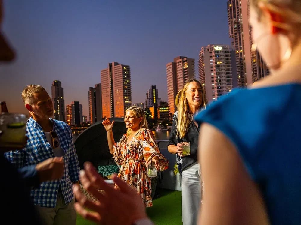 Guests enjoying an evening on deck beside the city skyline